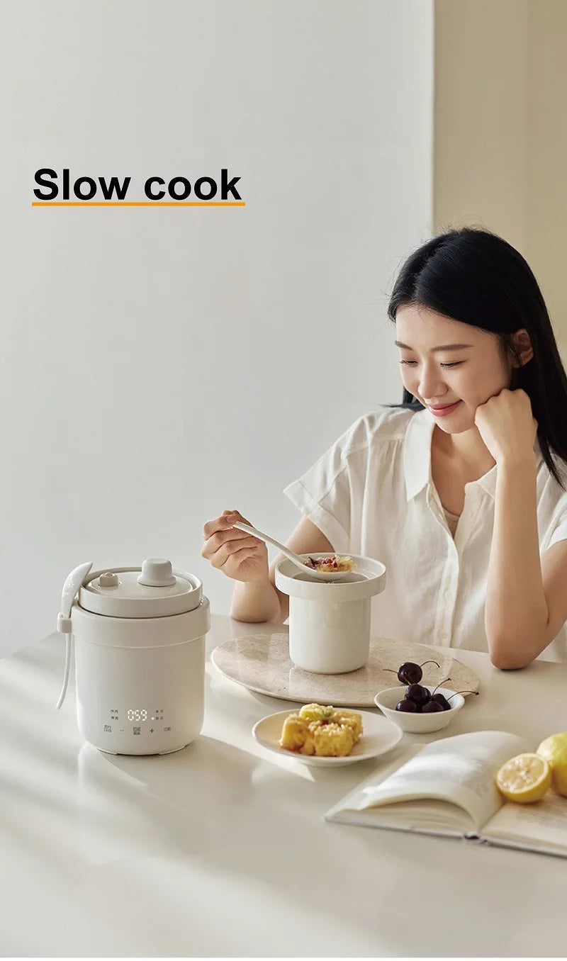 Smart white 600ml mini electric rice cooker used at table with small plated meals.