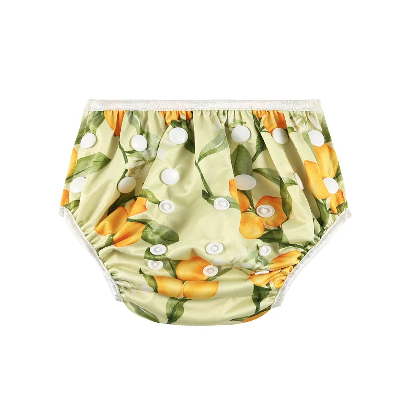 Adjustable cloth baby diaper with yellow lemon print and white snap buttons.