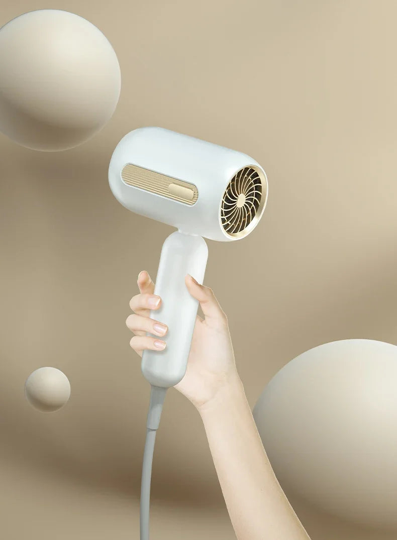 White F41 high-speed hair dryer with gold accents, held in hand, features sleek design for fast, low-noise drying.