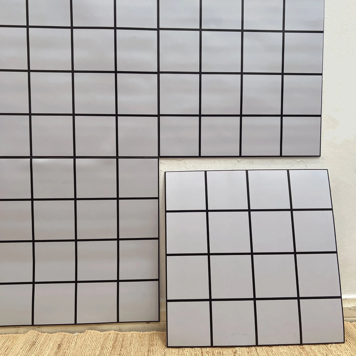 Peel-and-stick backsplash tiles in white with grid lines; square tile sheet