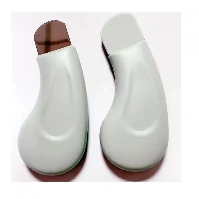 Two ergonomic, light green facial pore cleaners; one with a metallic blade, the other with a protective cap.