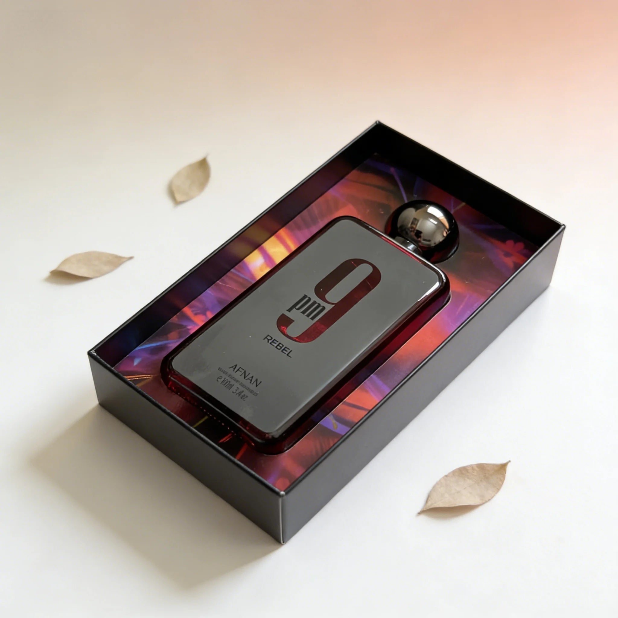 Afnan 9pm Rebel EDP for men: 3.4oz woody oud fragrance in a sleek rectangular bottle with a metallic round cap.