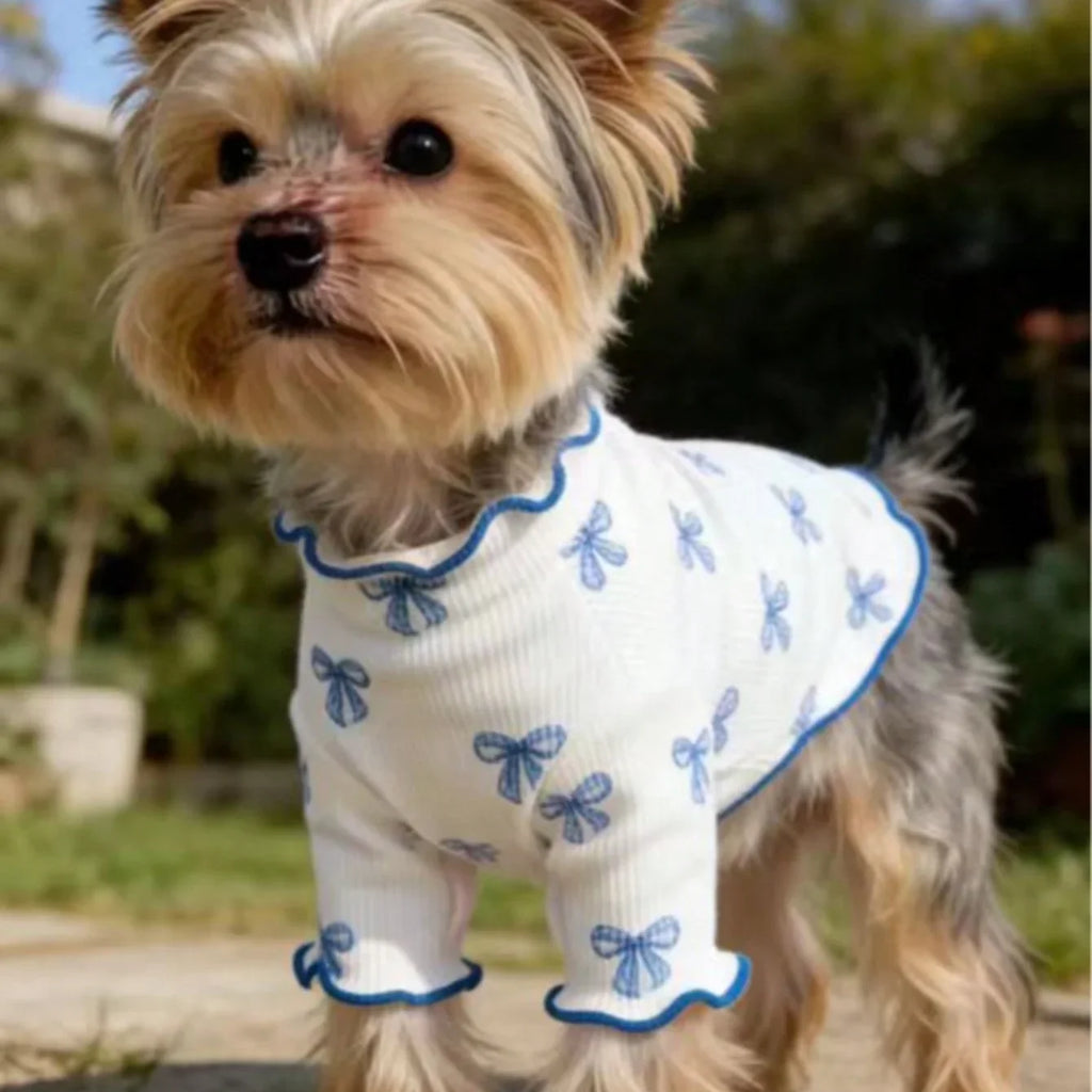 Small dog wearing a breathable, stretchy white knit shirt with blue bow tie print for comfortable pet fashion.