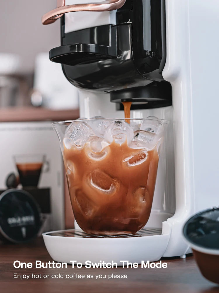 White single-serve coffee maker brewing iced coffee into a glass with copper accents and pod compatibility.