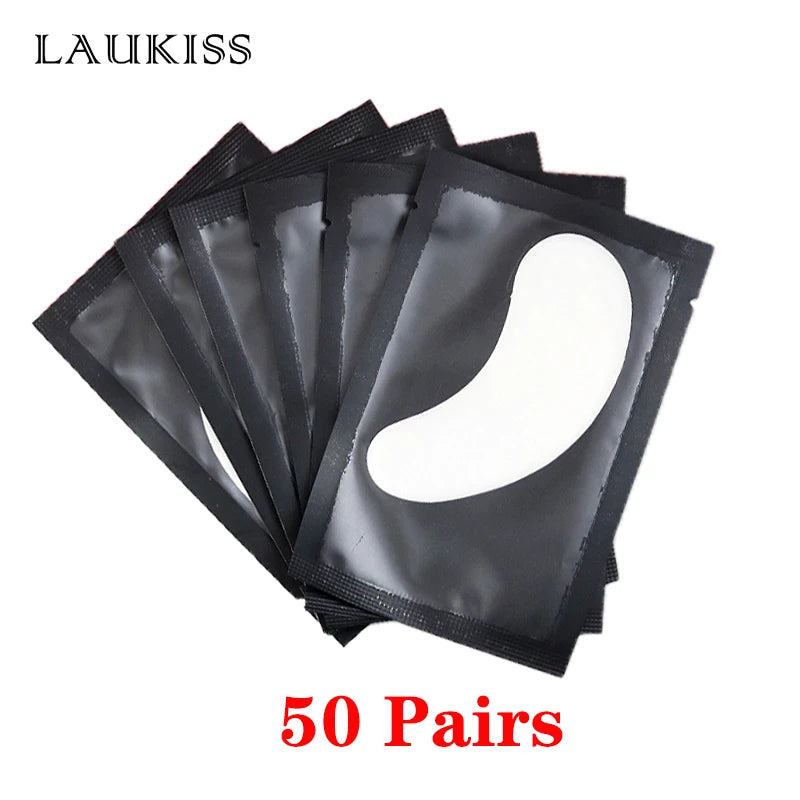 Lint-free white under eye gel patches in individual black wrappers for eyelash extension application.