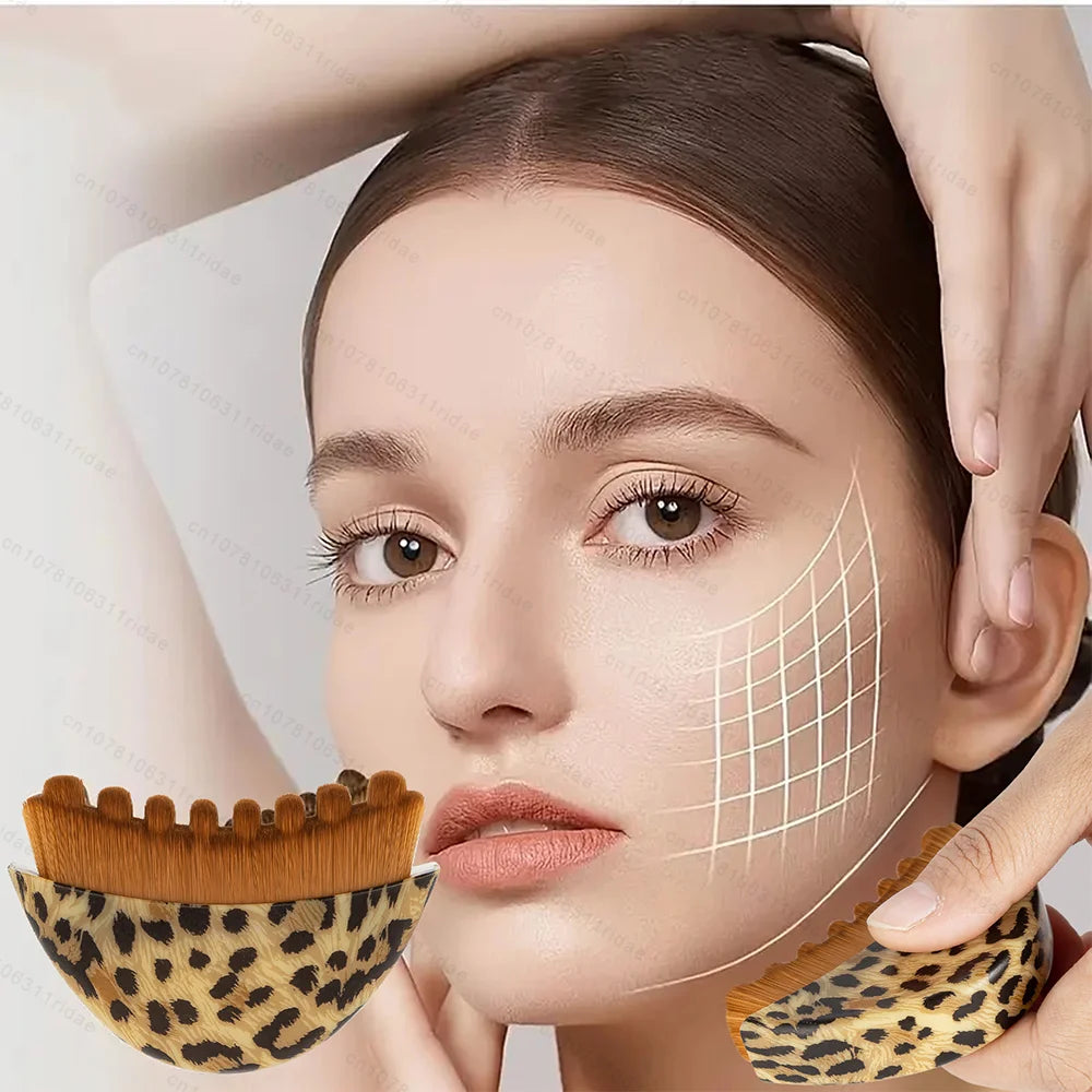 Leopard-print gua sha face massage brush with brown bristles held against a woman’s face with a grid overlay.