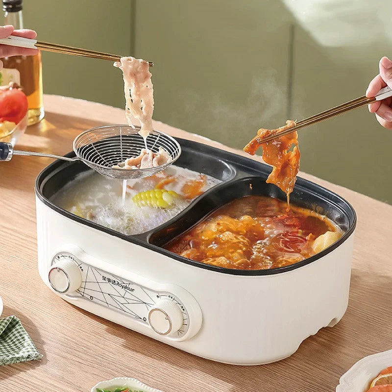 White dual-compartment electric hot pot with black non-stick liners, simmering food