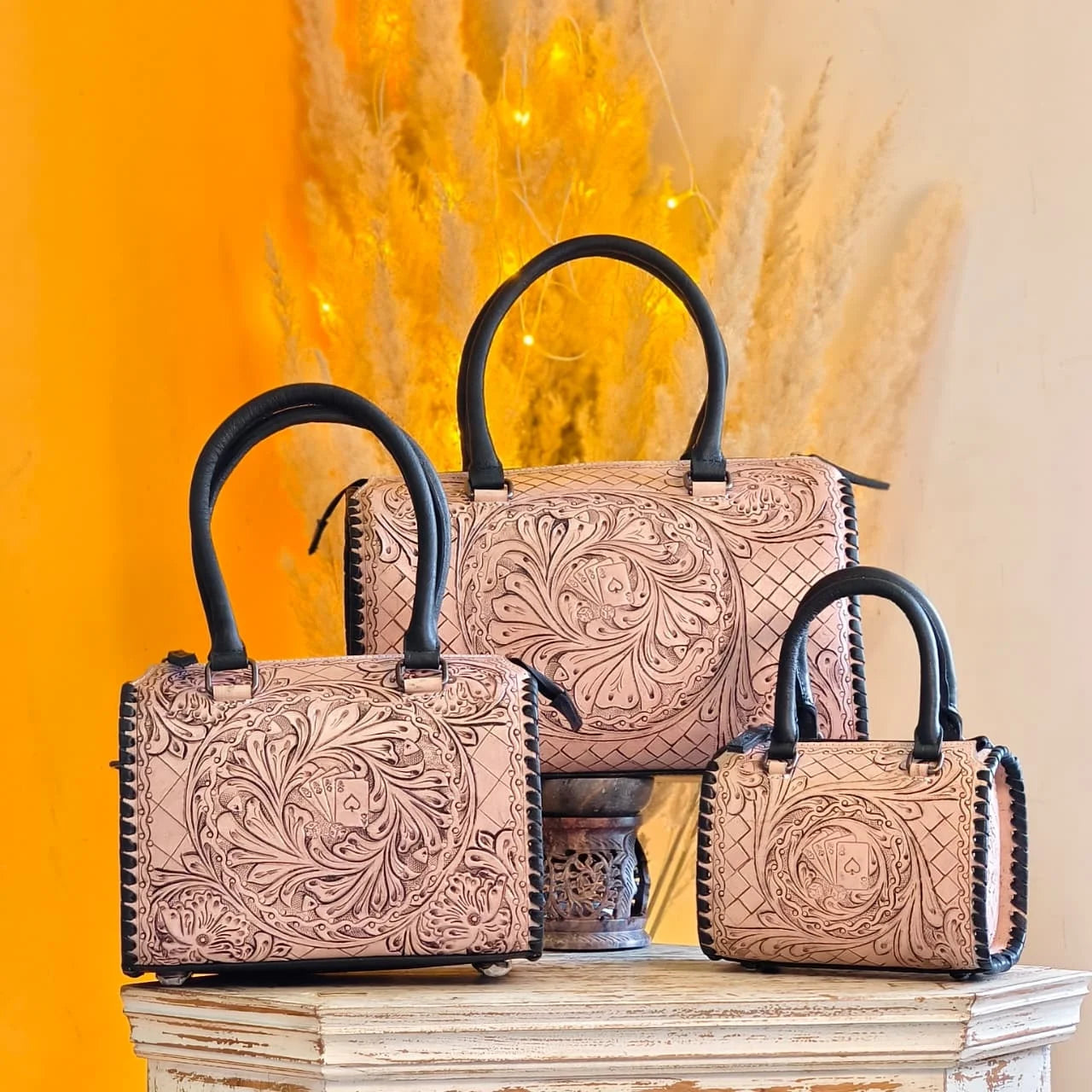 Luxury hand-tooled genuine leather trunks, floral carved speedy duffle bags with black handles and ace card motif.