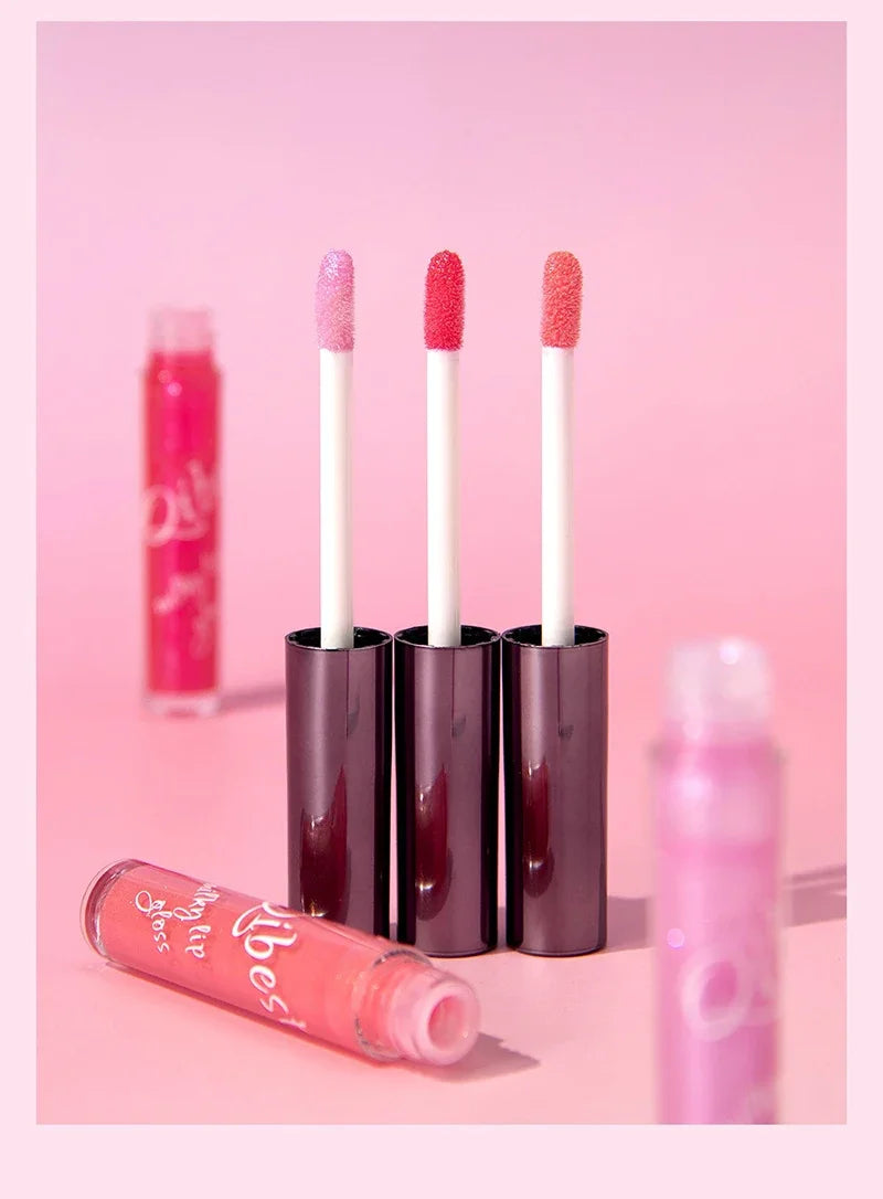 Shimmering taro purple and pink lip gloss wands for a moisturizing, plumping, glassy jelly shine on a pink background.