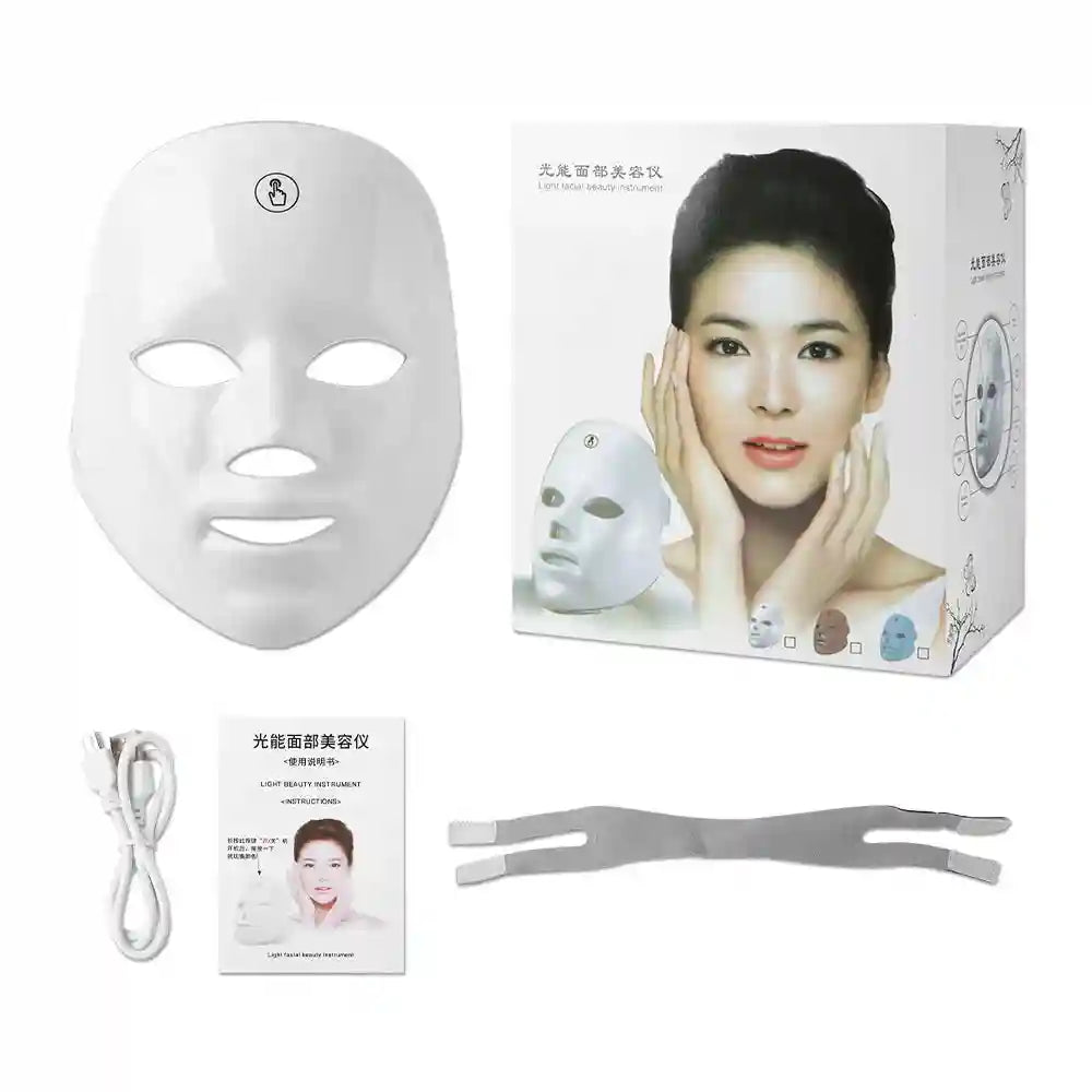 White LED facial beauty mask with its product box, instruction manual, charging cable, and a grey elastic headband.