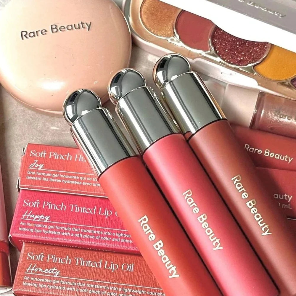 Rare Beauty Soft Pinch Tinted Lip Oil collection in various shades with sleek packaging and hydrating gel texture.