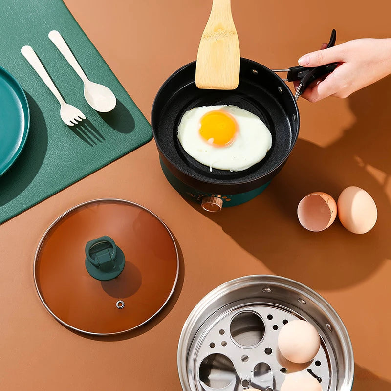 Teal electric cooker with black fry pan insert and accessories, for travel cooking
