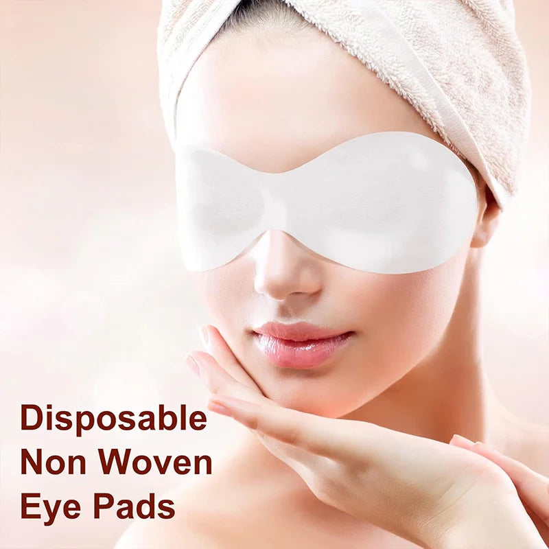 A person wearing a white, disposable, shaped cotton eye mask over their eyes with a towel wrap on their head.