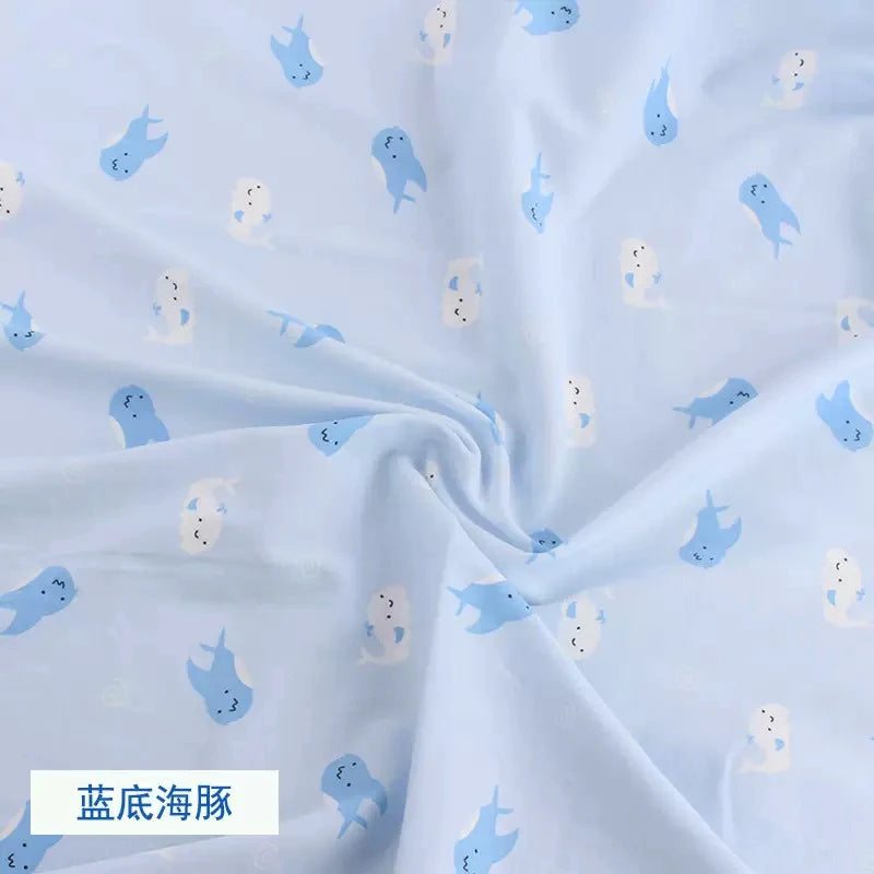 Light blue knit jersey fabric with a cute white and blue dolphin print, bunched to show soft texture.