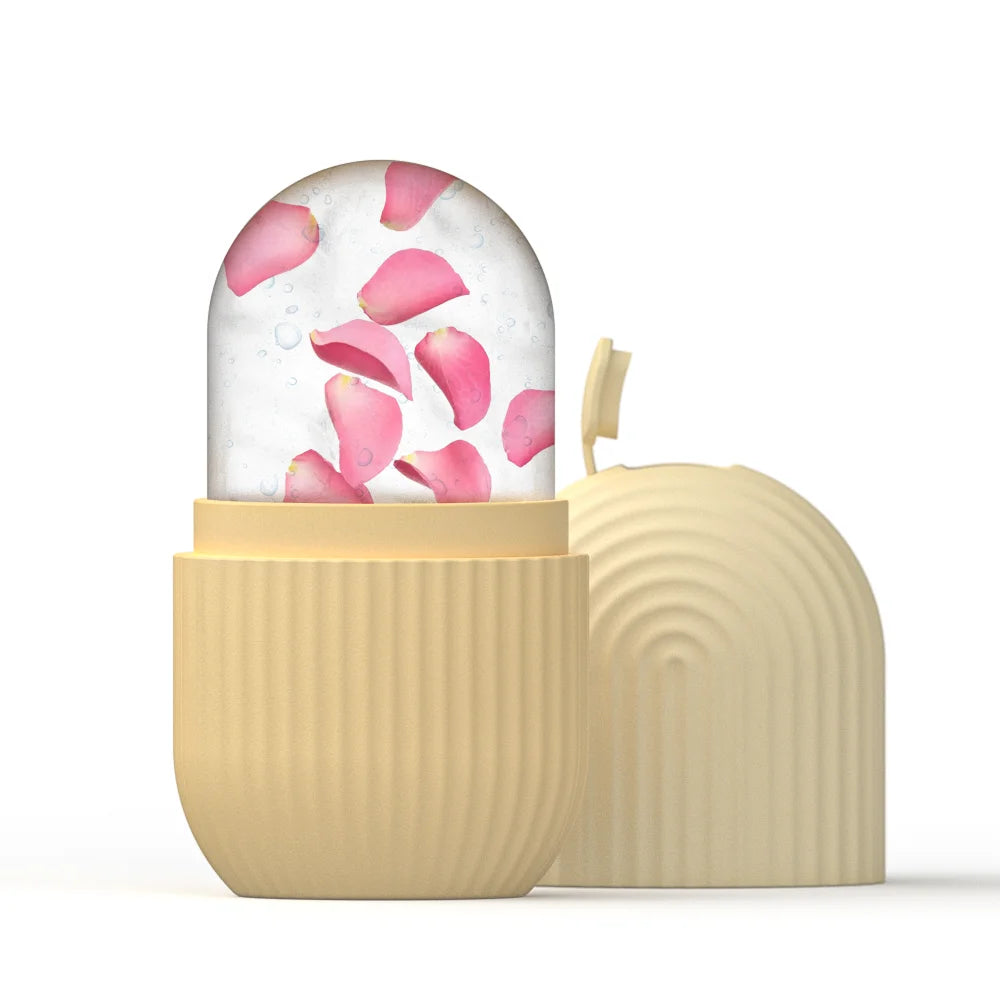 Beige, ribbed silicone ice roller mold containing frozen water and pink rose petals, with a matching removable lid.