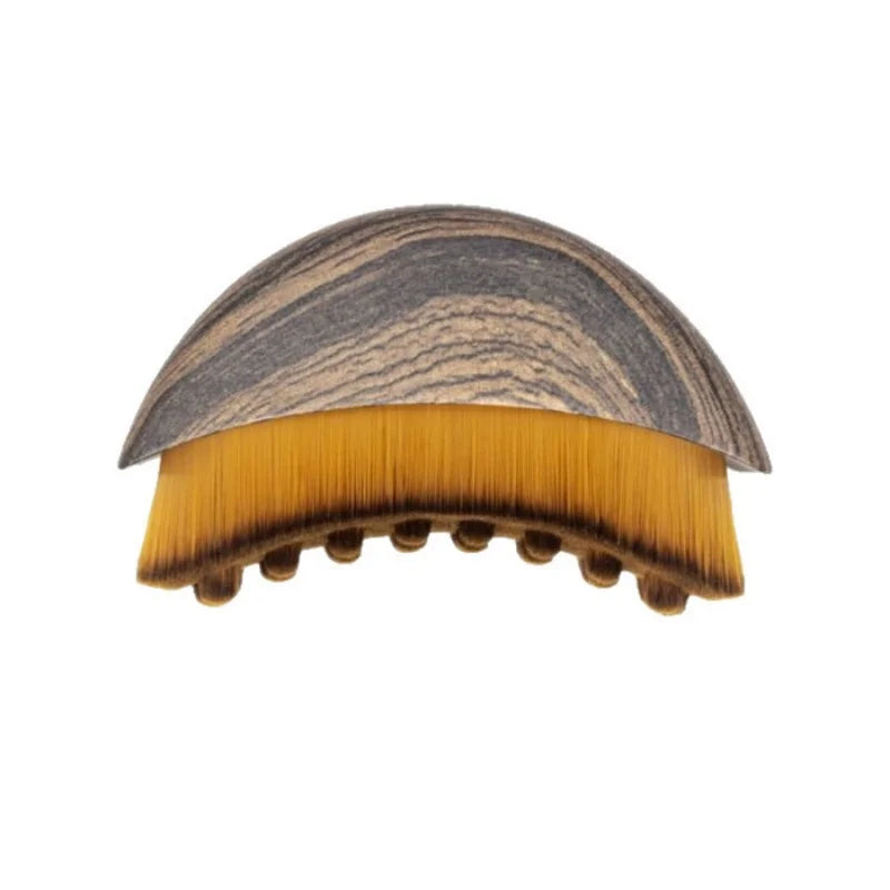 Soft fiber facial massage brush with wood-grain handle for lymphatic drainage, contouring, and puffiness reduction.