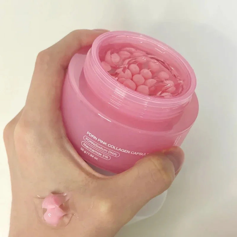 Hand holding a pink jar of Korean Collagen PDRN capsule cream, showing small pink spheres in clear gel.