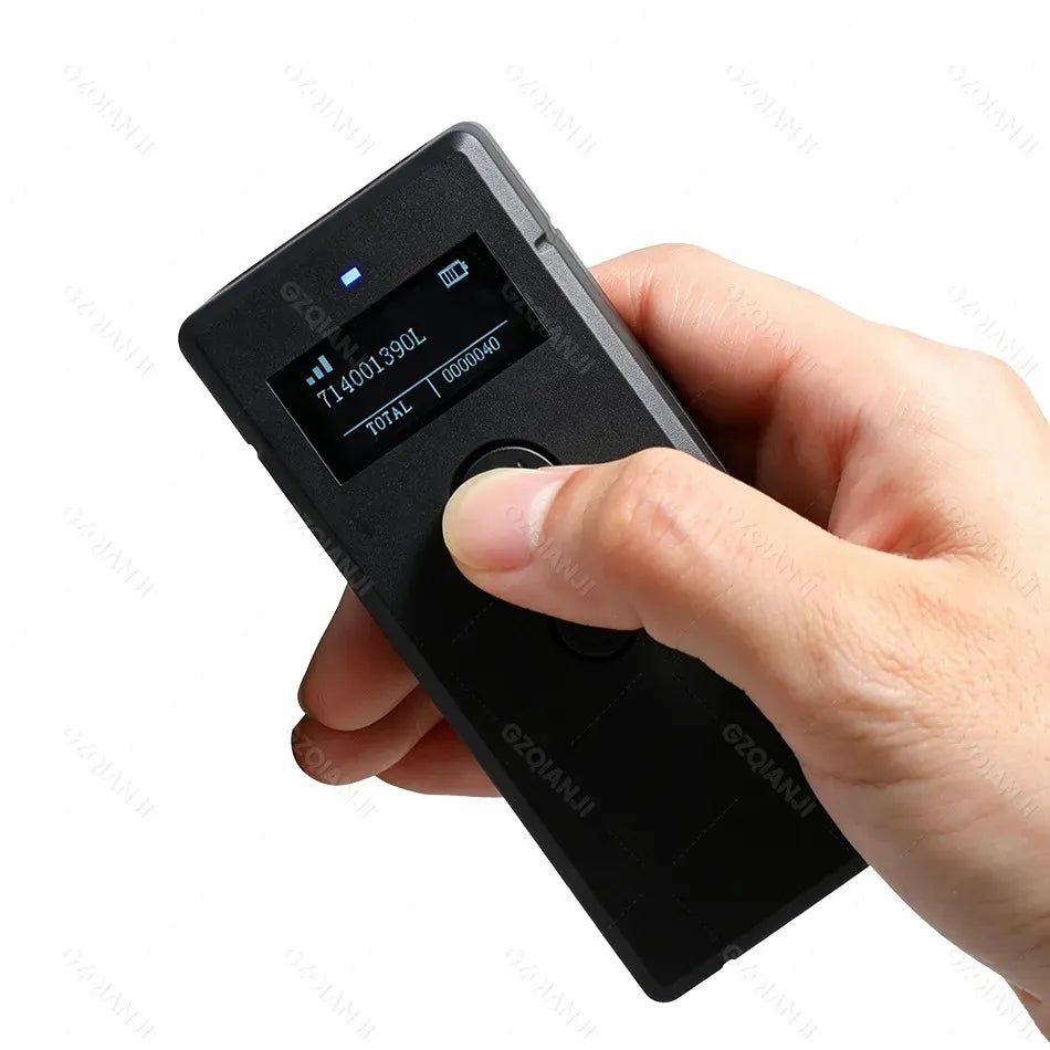 Hand holding wireless 2D barcode scanner with display showing scanned code