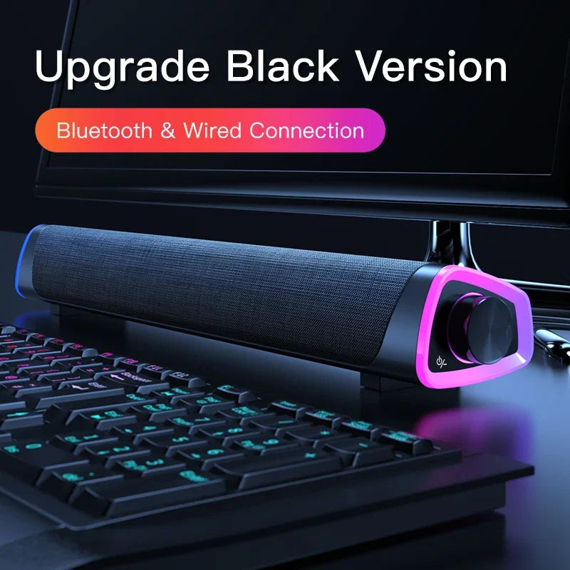 Computer speaker bar in dark fabric with glowing RGB ring and front dial