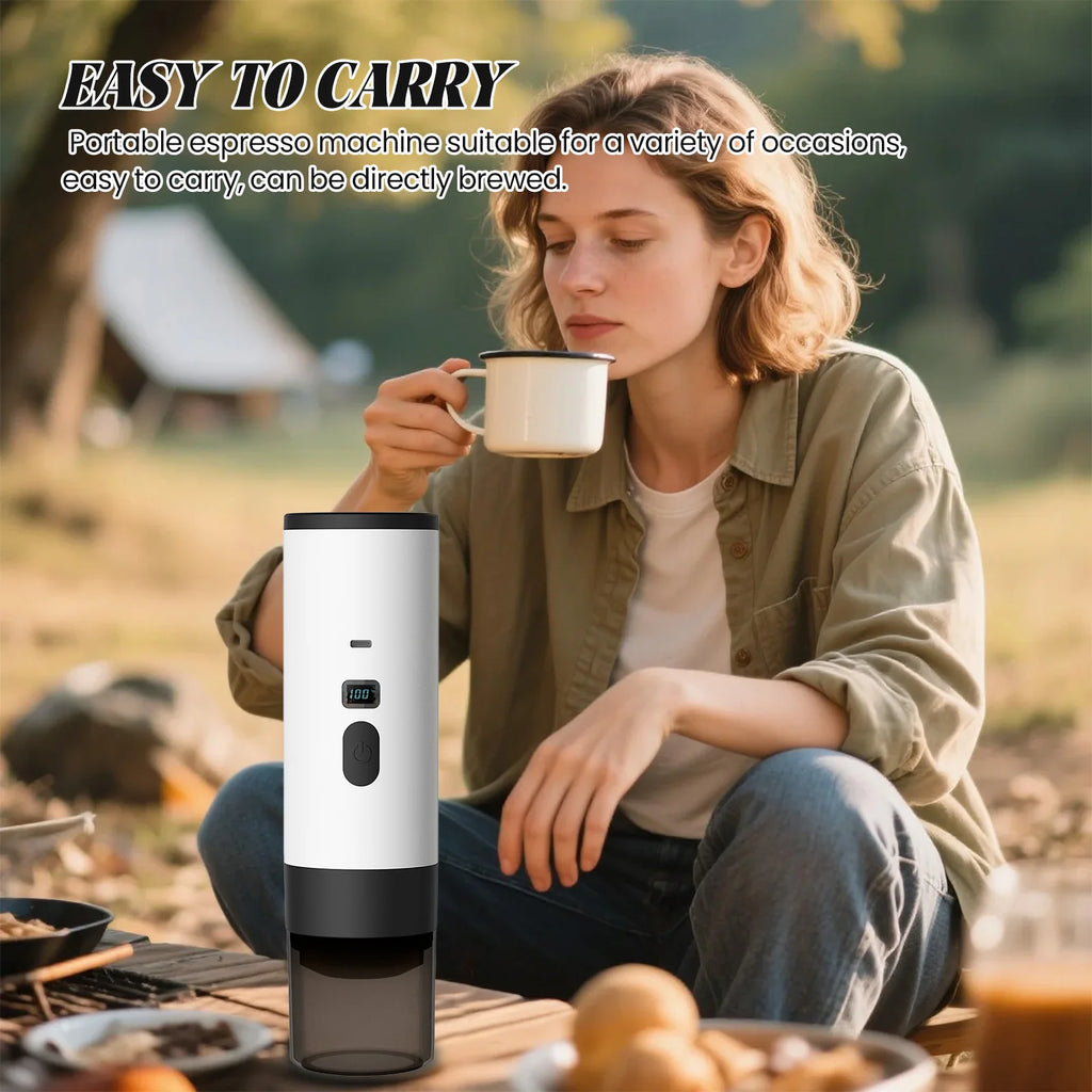 White portable electric espresso maker with digital display, used for camping and outdoor coffee brewing.
