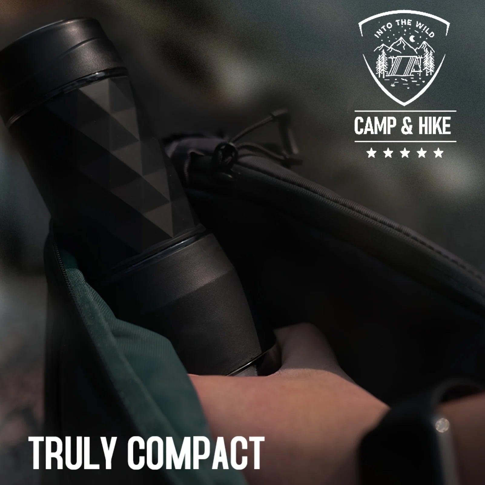 Compact black geometric travel coffee maker in a bag, ideal for camping and hiking gear, held by a hand.