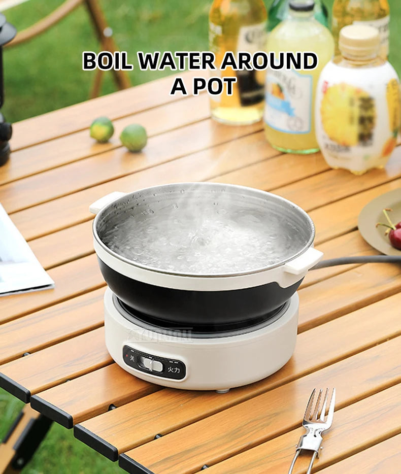 Portable electric cooking pot with metal pan and black bowl on white base, boiling water