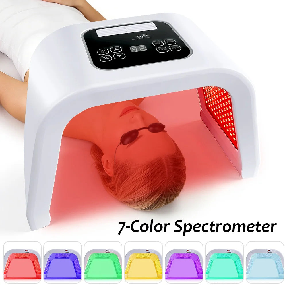 White LED facial therapy arch with digital controls, shown in use with red light over a person wearing goggles.