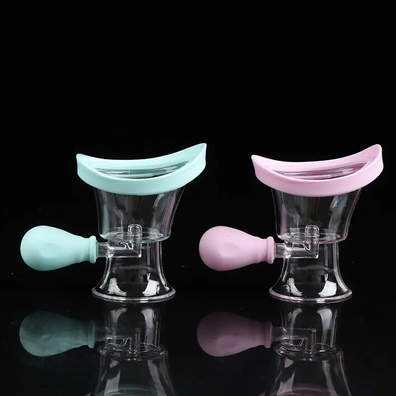 Reusable silicone eye wash cups with squeeze bulbs for rinsing and cleaning eyes, blue and pink, isolated on black.