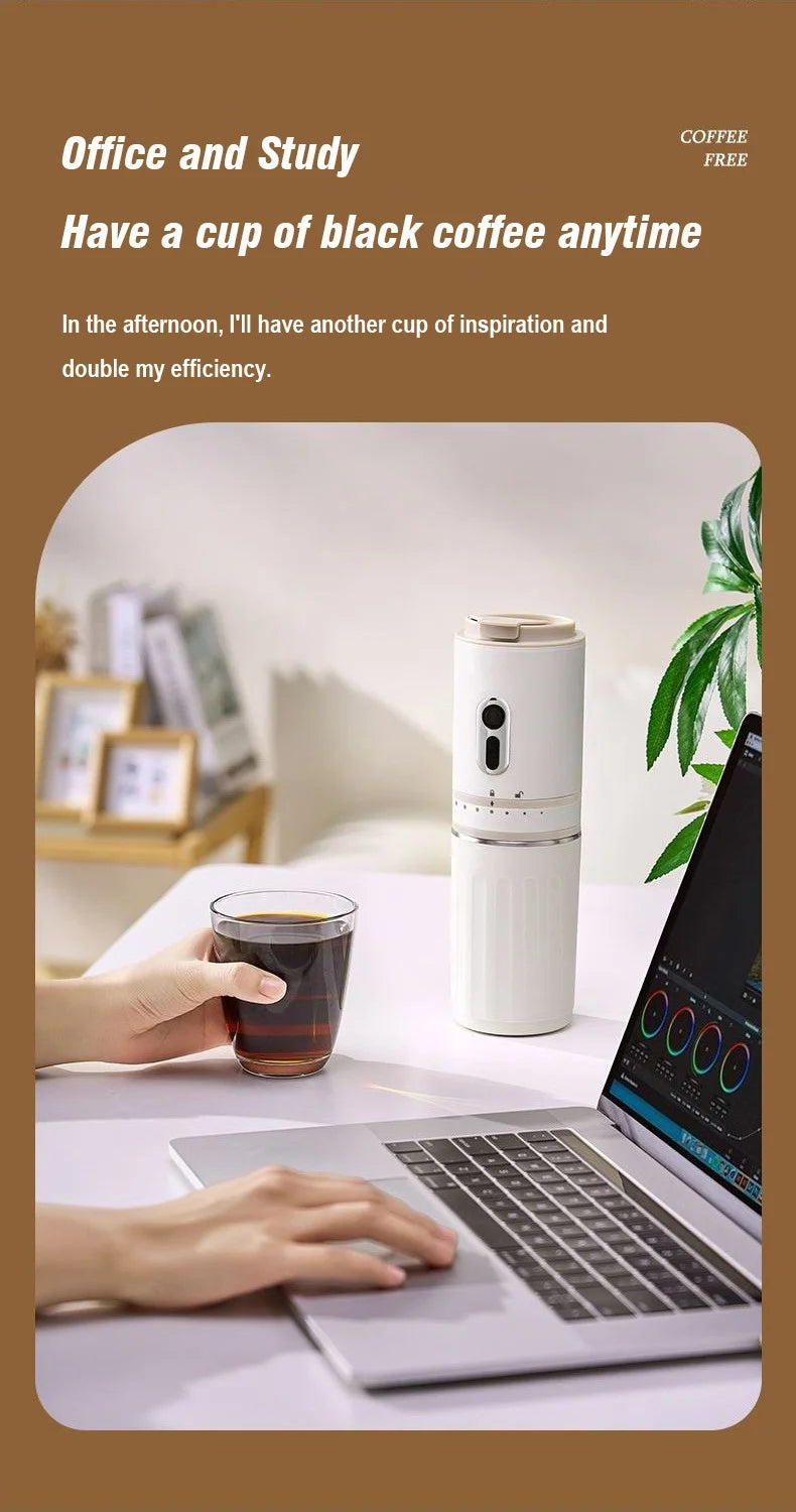 White portable coffee maker on office desk next to laptop with user holding a glass of black coffee.