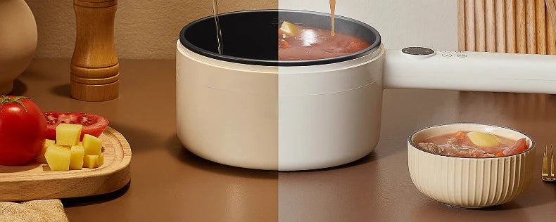 White electric cooker pot with simmering liquid and matching inner bowl