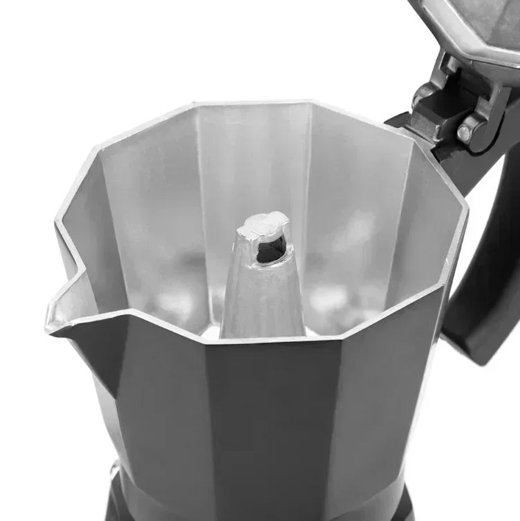 Interior of an open grey aluminum moka pot coffee maker showing the octagonal basin and central coffee funnel.