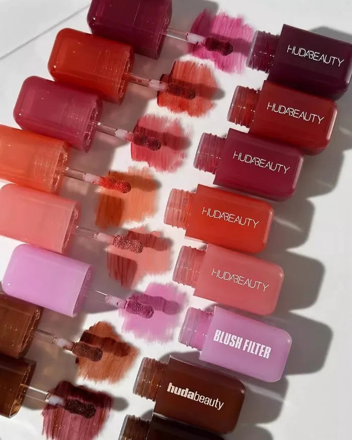 Huda Beauty Blush Filter hydrating lip and cheek tint sticks in assorted shades with textured cream swatches.
