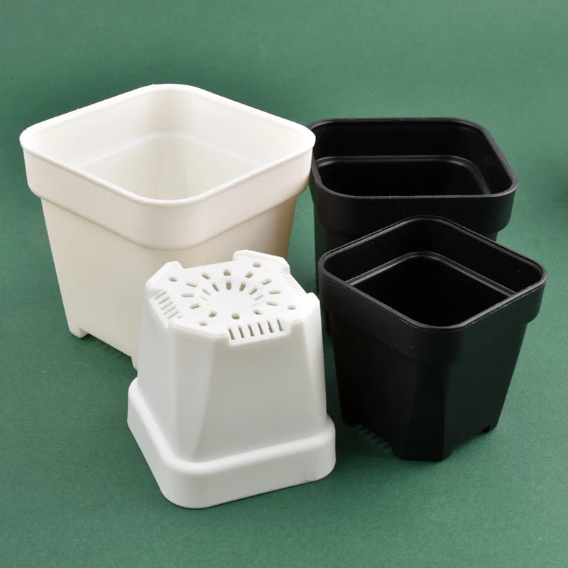 Square planter pots in white and black with drainage inserts, close view