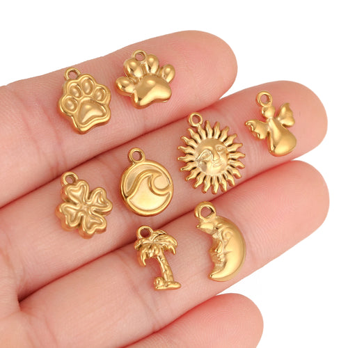 Close-up of gold-tone pet paw, crescent moon, sun and heart charm pendants