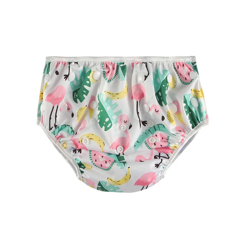Reusable baby swim diaper with flamingo, tropical leaf, and fruit print featuring adjustable snap buttons.