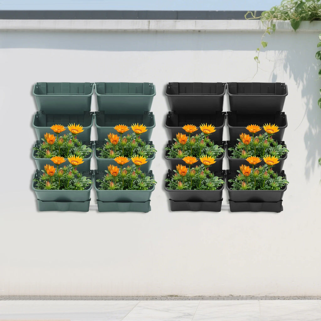 Wall-mounted vertical planter set with orange flowers and greenery in green and black planters