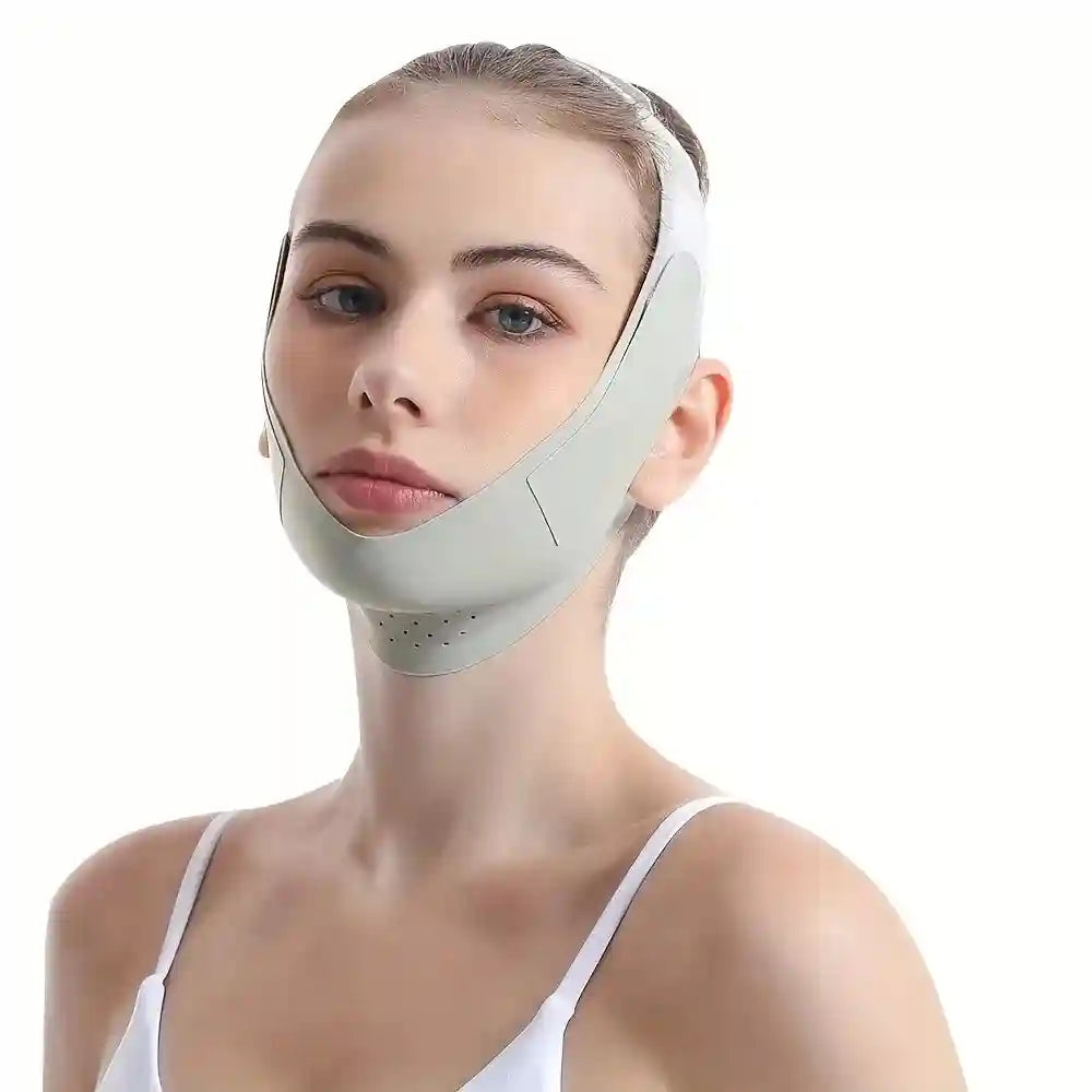 Woman wearing a light gray, perforated silicone V-line face slimming bandage strap over her chin and cheeks.