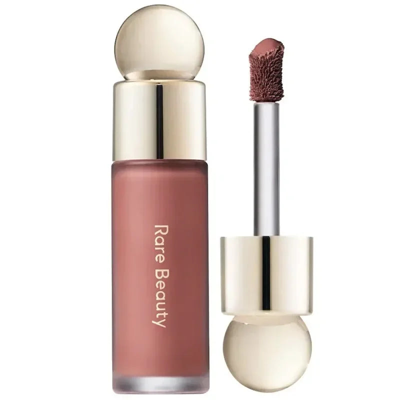 Rare Beauty matte liquid lipstick in a rich, smooth mauve shade with a gold-capped applicator wand.