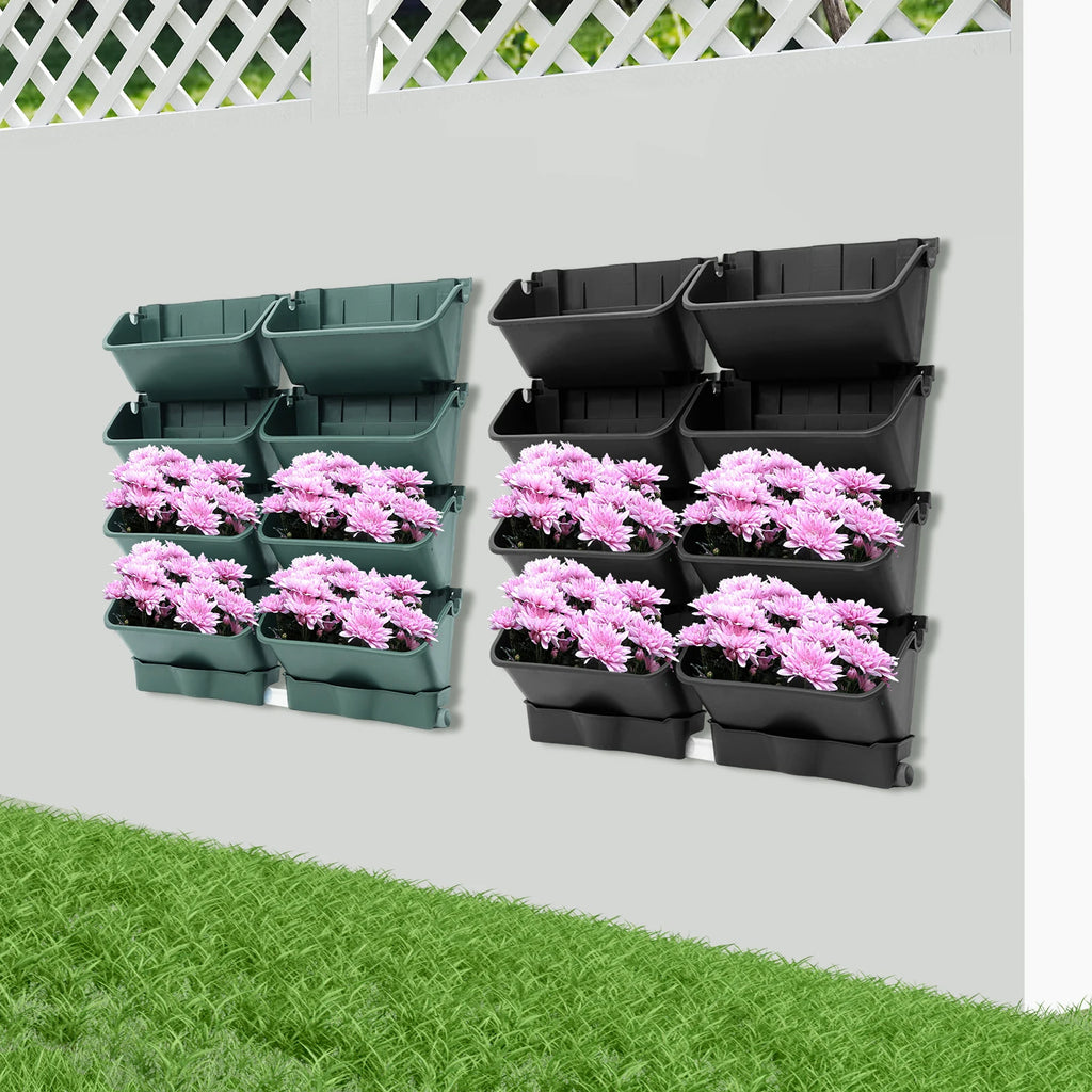 Wall-mounted vertical planter set with pink flowers in green and black wall planters