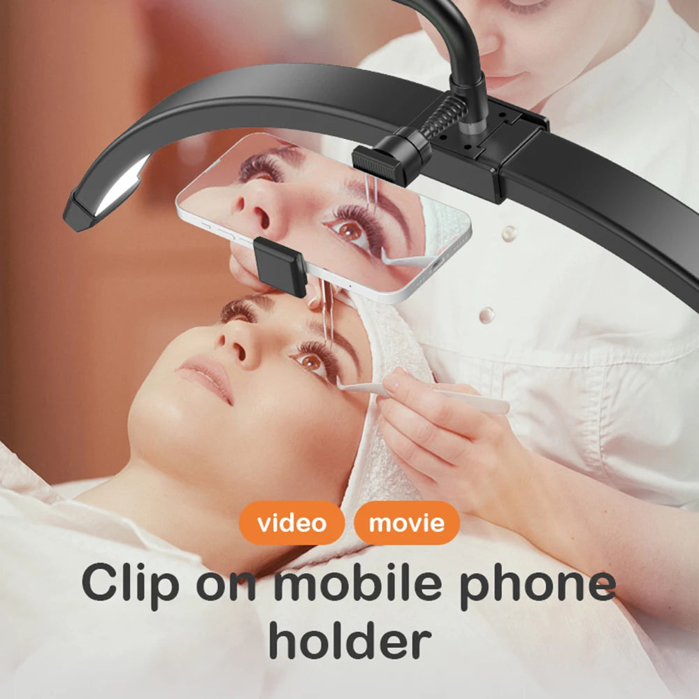Black curved LED half-moon light with an adjustable phone holder for filming beauty treatments and lash application.