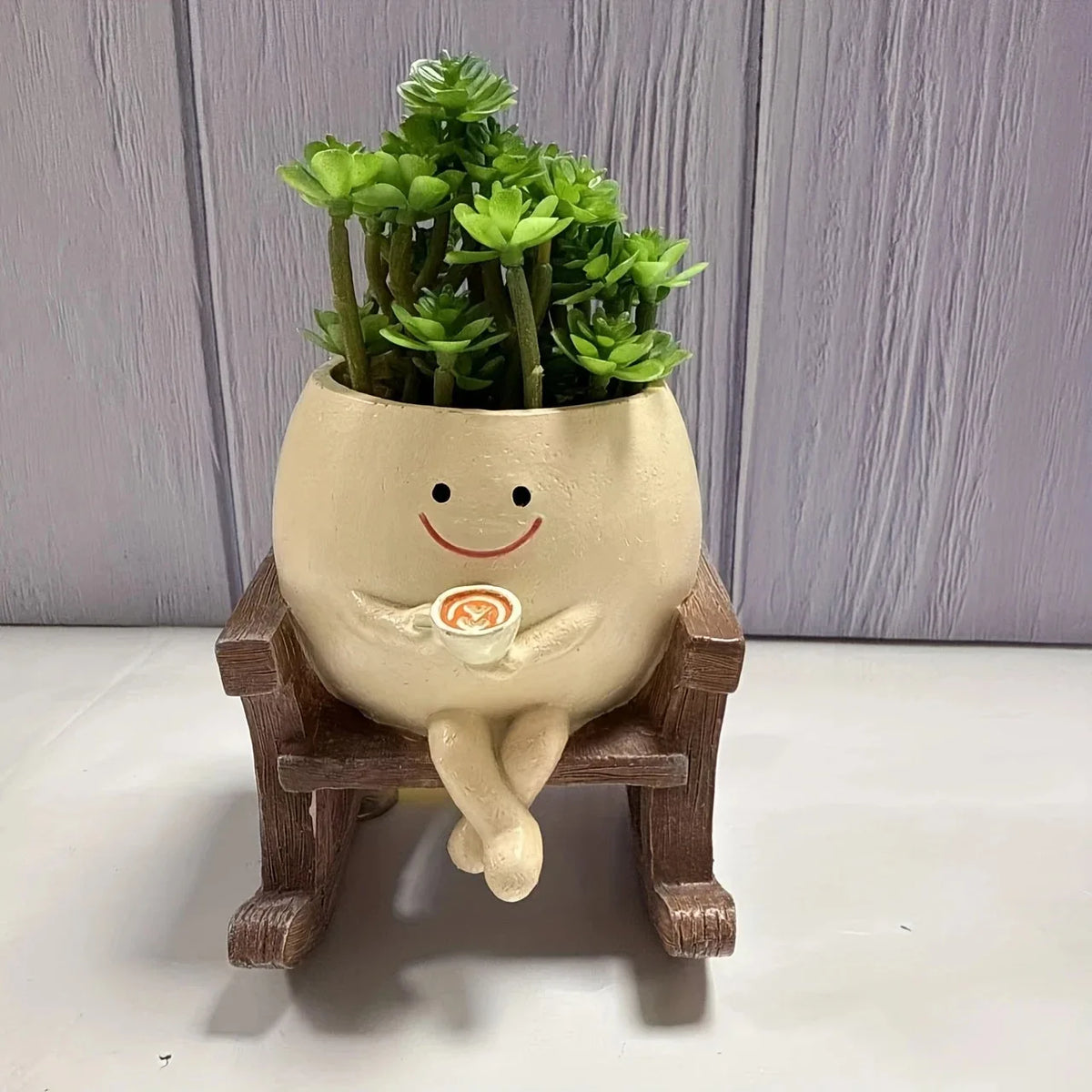 Mini standing succulent planter with smiling face on wooden stool, green succulents on top