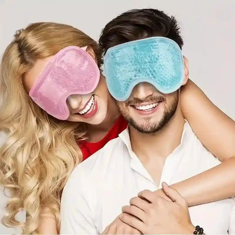 A smiling couple wearing pink and light blue gel bead eye masks for hot and cold therapy.