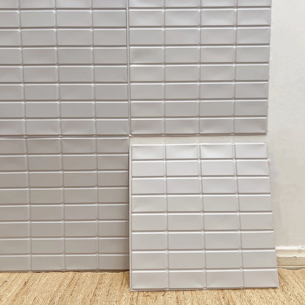 White square peel-and-stick backsplash tile sheet with subtle raised texture
