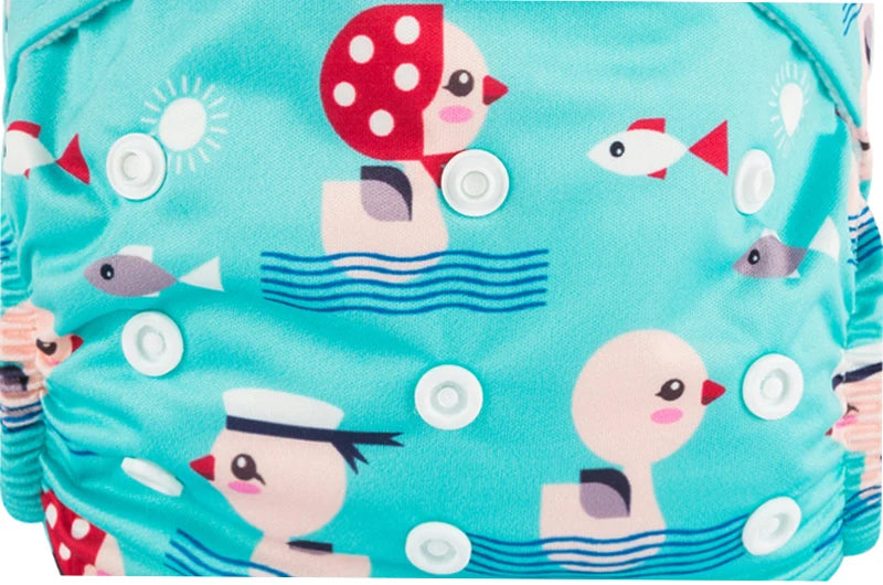 Reusable cloth baby diaper with adjustable snaps and cute duck and fish pattern on a teal background.