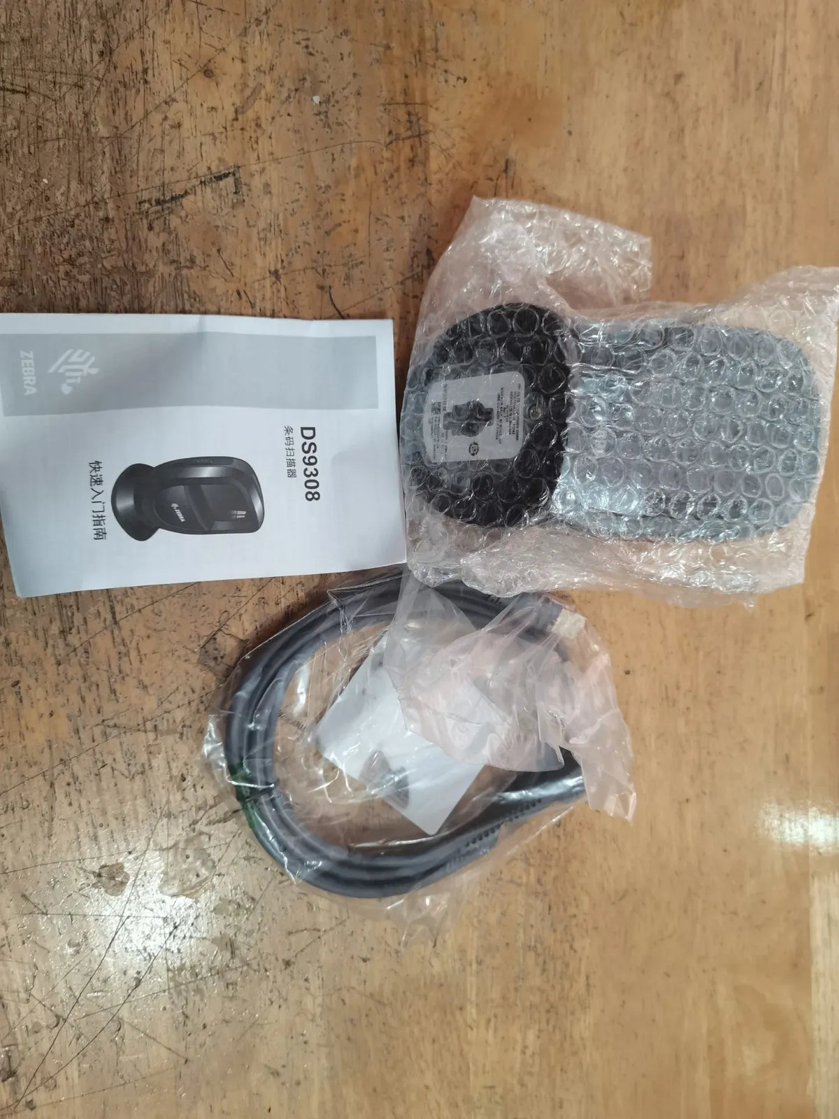 Zebra DS9308 barcode scanner in bubble wrap with included cables and papers