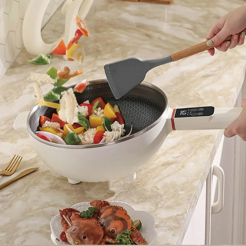 Electric frying pot with wooden spatula and mixed vegetables cooking inside
