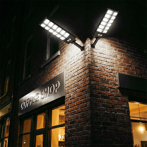 Solar wall street lights with dual LED heads mounted at a corner on brick