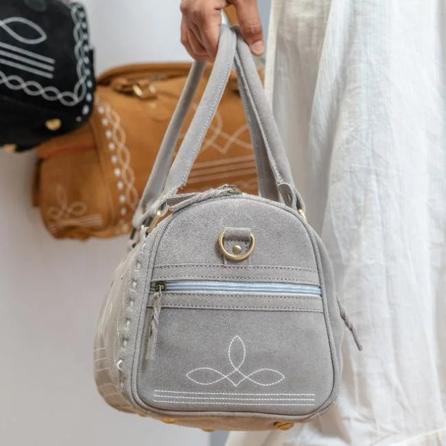 Grey genuine suede leather duffel bag with decorative white boot stitch detailing for weekend travel.
