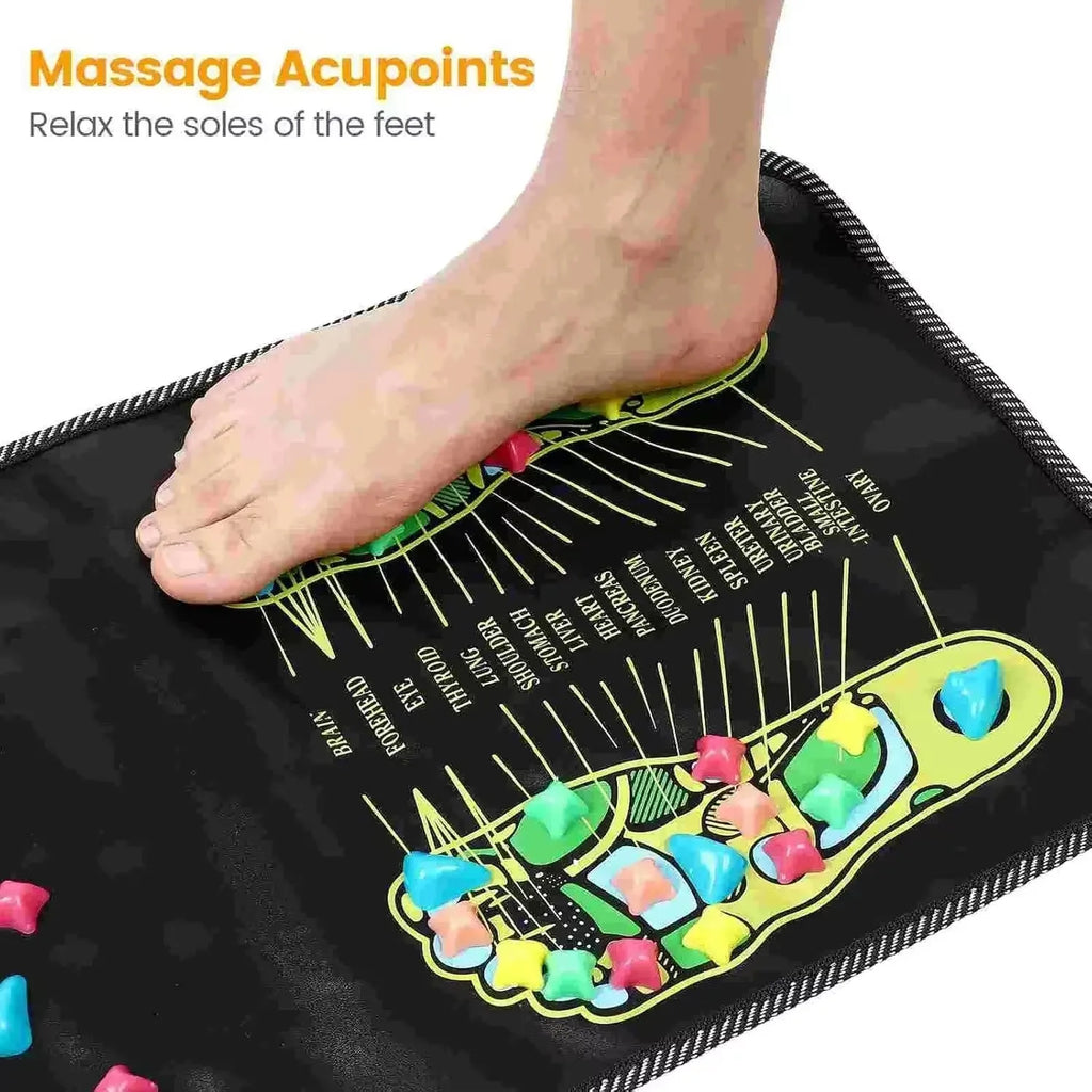 Foot standing on black acupressure reflexology massage pad with colorful pressure points for pain relief and health.