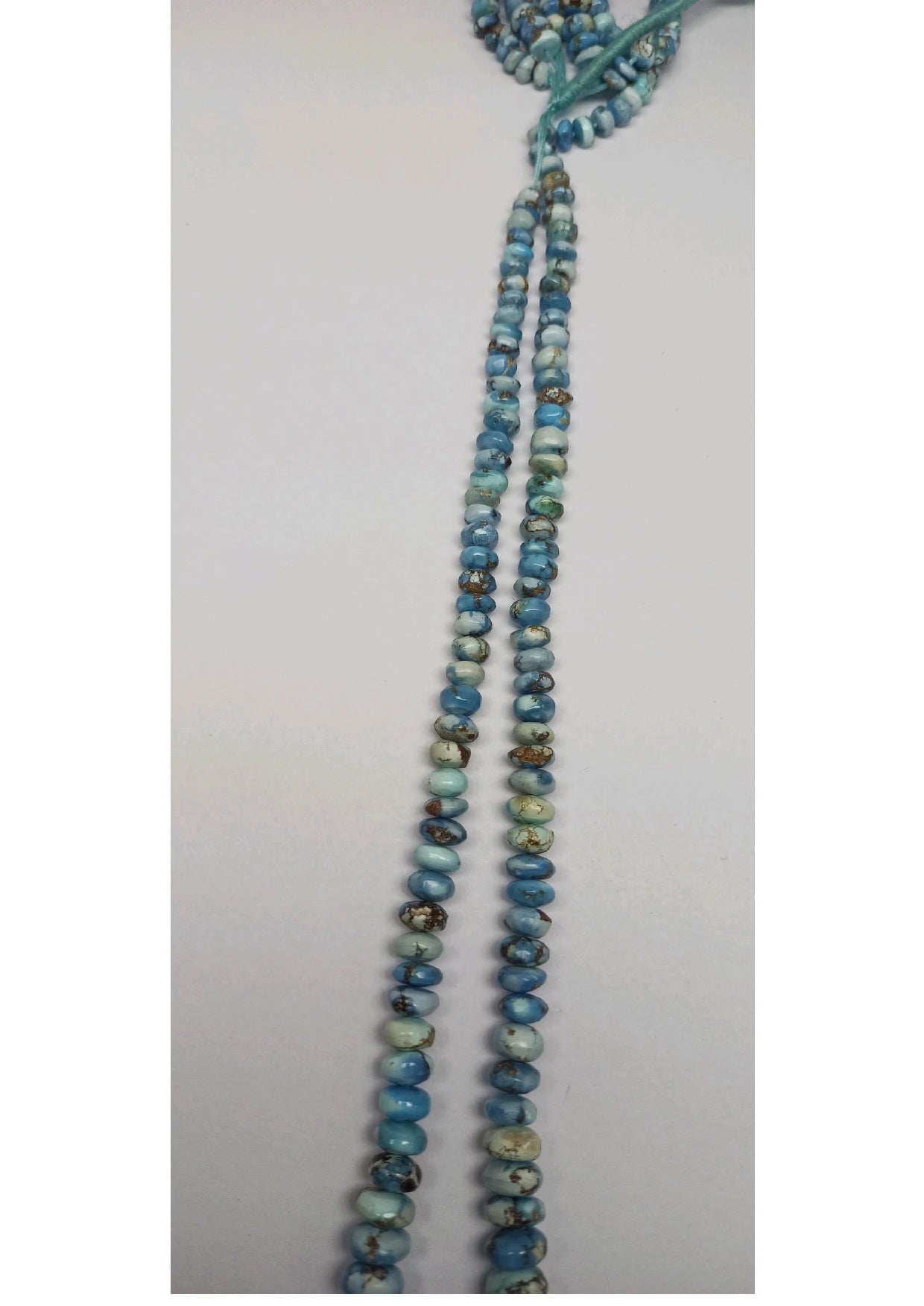 Turquoise rondelle beads strand detail, small smooth beads in stacked rows on loop
